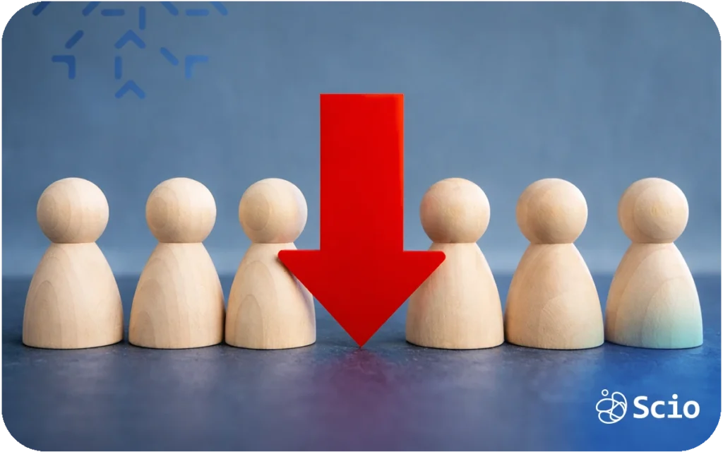 Wooden figures in a row with a red arrow pointing down at one, symbolizing team dependency risk and the Bus Factor concept.