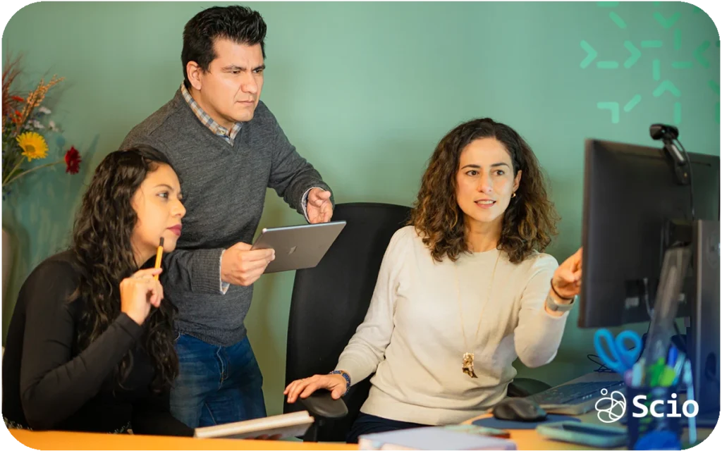 Software development team reviewing work together in front of a computer screen