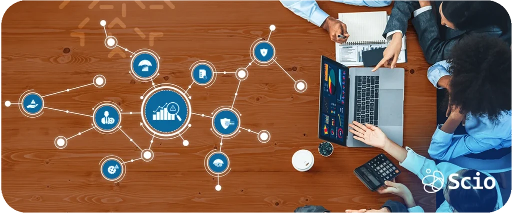 Small IT department challenges: team of IT professionals collaborating on a laptop with digital network icons representing the technology challenges that lean IT teams navigate with limited resources