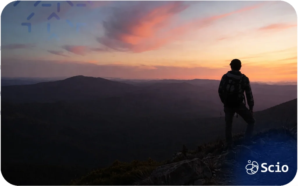 Engineer standing on a mountain peak at sunrise, symbolizing leadership perspective and long-term progress