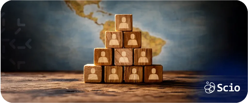 Stacked wooden blocks with team icons placed over a map of Latin America, representing structured nearshore team building.