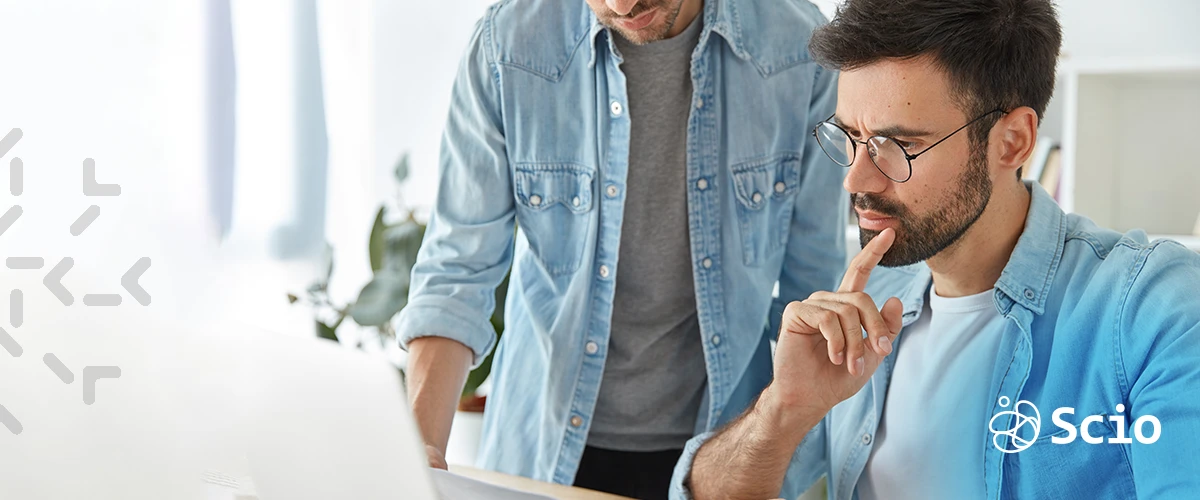 Developers collaborating to solve software project challenges. Two software engineers collaborating on a project, discussing code details in a nearshore development environment.