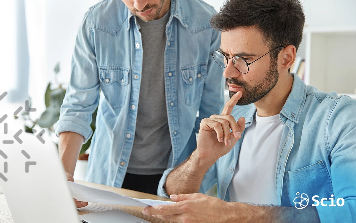 Two software engineers collaborating on a project, discussing code details in a nearshore development environment.