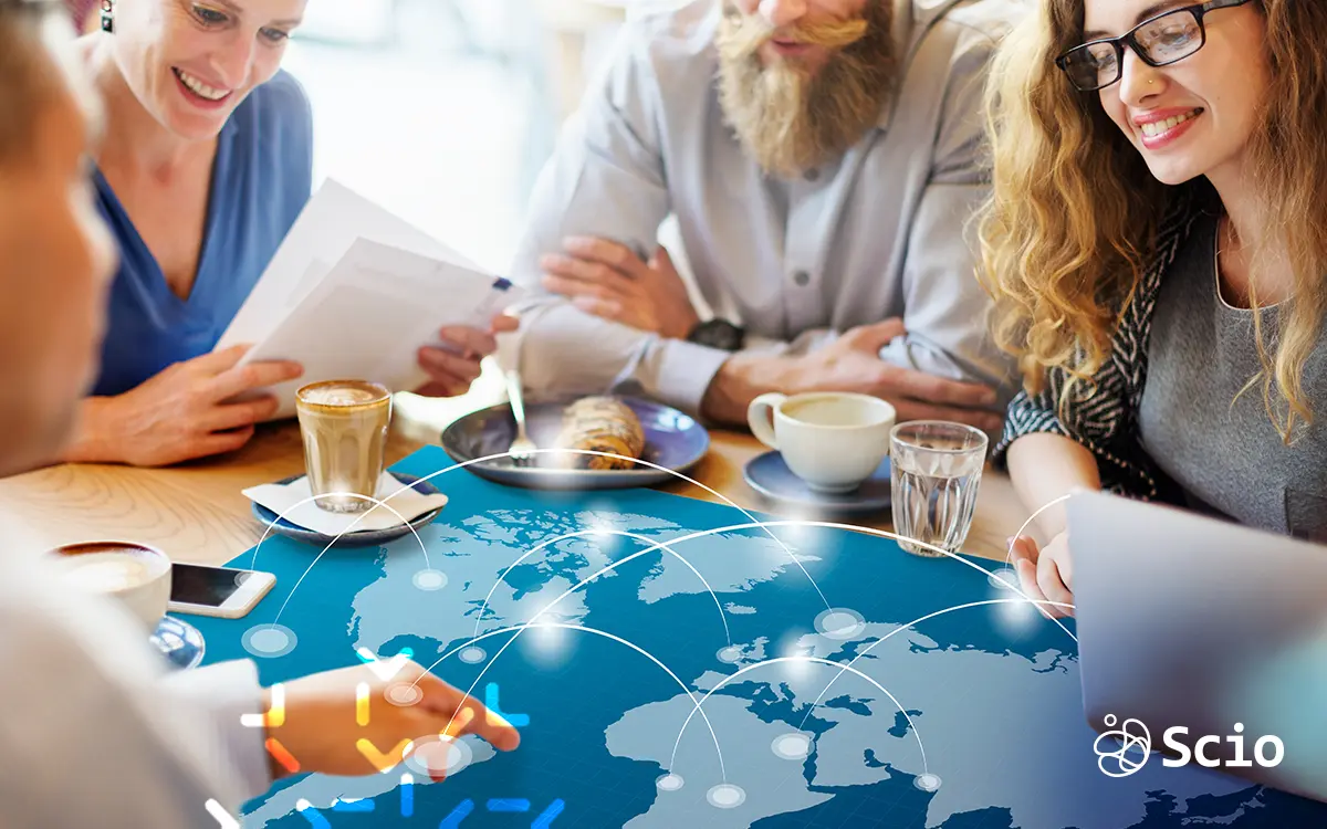 Scio team collaborating over a digital world map, representing strategic nearshoring opportunities in Mexico and Latin America