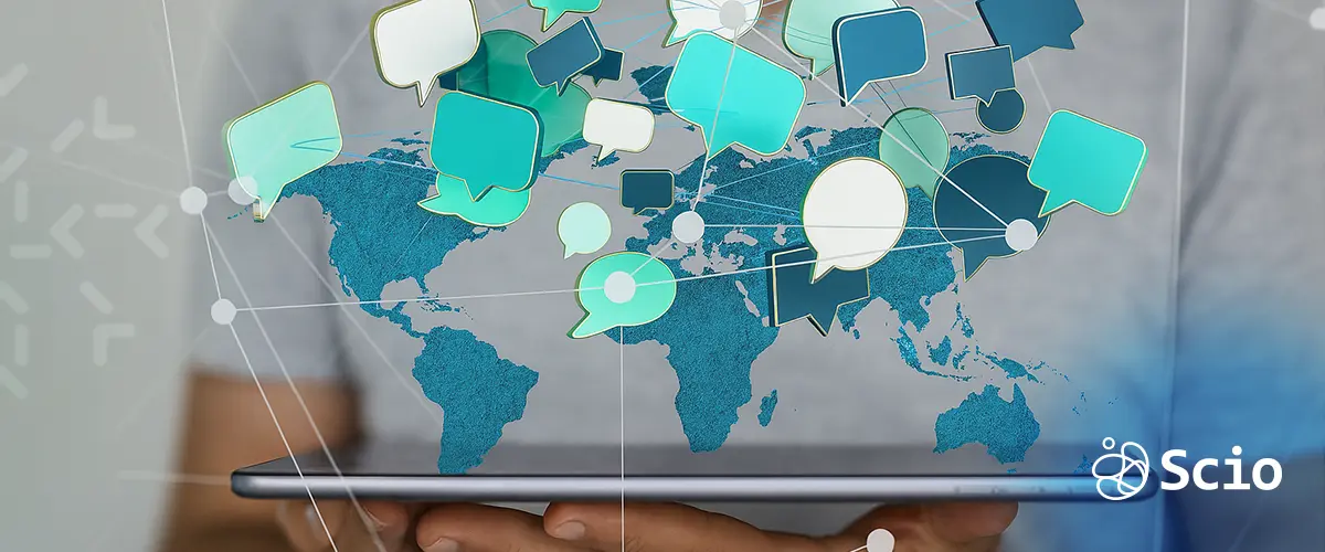 Digital speech bubbles over a world map on a tablet, representing global communication challenges in offshore software development