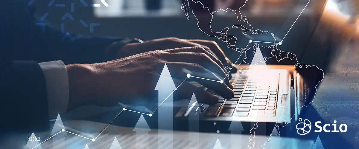 Close-up of hands typing on a laptop with data overlay, representing the real cost and value of software development in Latin America for U.S. companies.