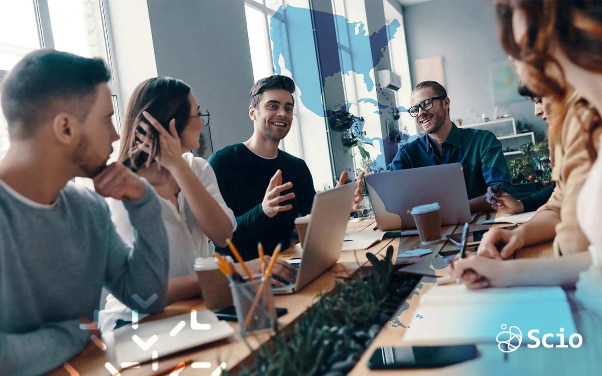 Team of nearshore software developers in Mexico and the U.S. collaborating in a modern meeting room, discussing project strategy and communication flow.