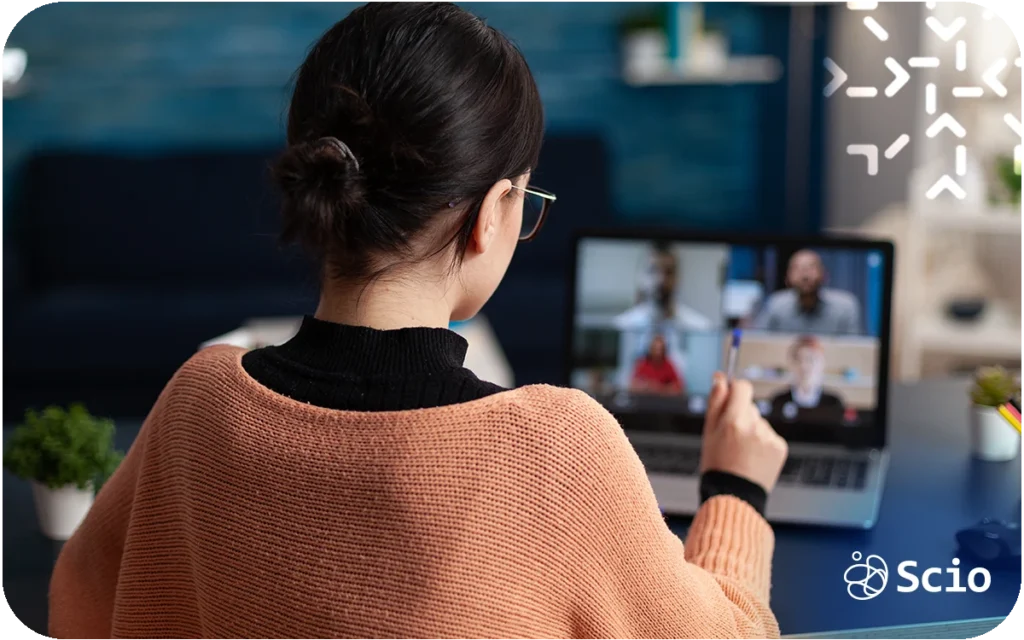 Nearshore software engineer in a remote workspace connecting with her distributed team through a video meeting, symbolizing trust and communication across screens.