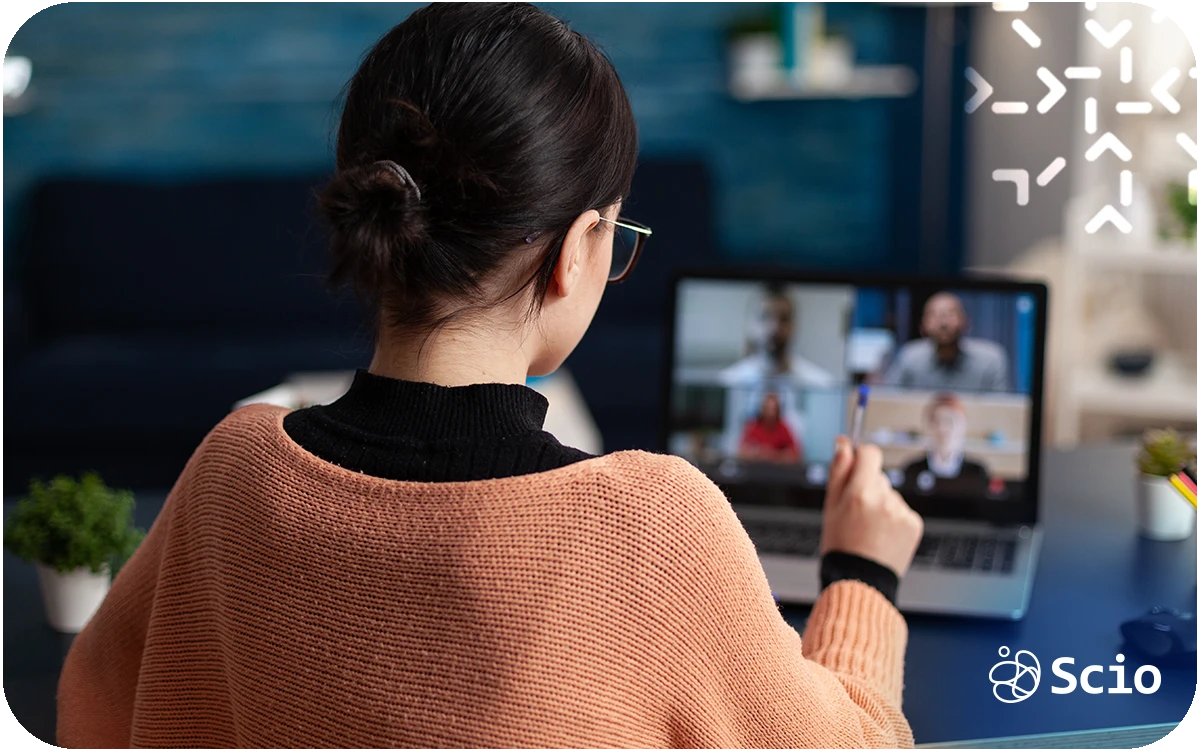 Nearshore software engineer in a remote workspace connecting with her distributed team through a video meeting, symbolizing trust and communication across screens.