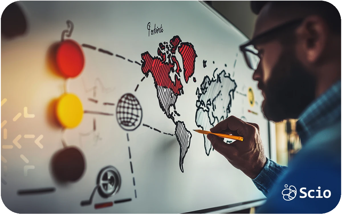 Software development manager analyzing a world map while planning outsourcing strategy to Latin America