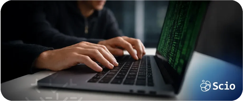Software engineer typing on a laptop with green code on the screen representing hybrid classical and quantum computing experimentation.